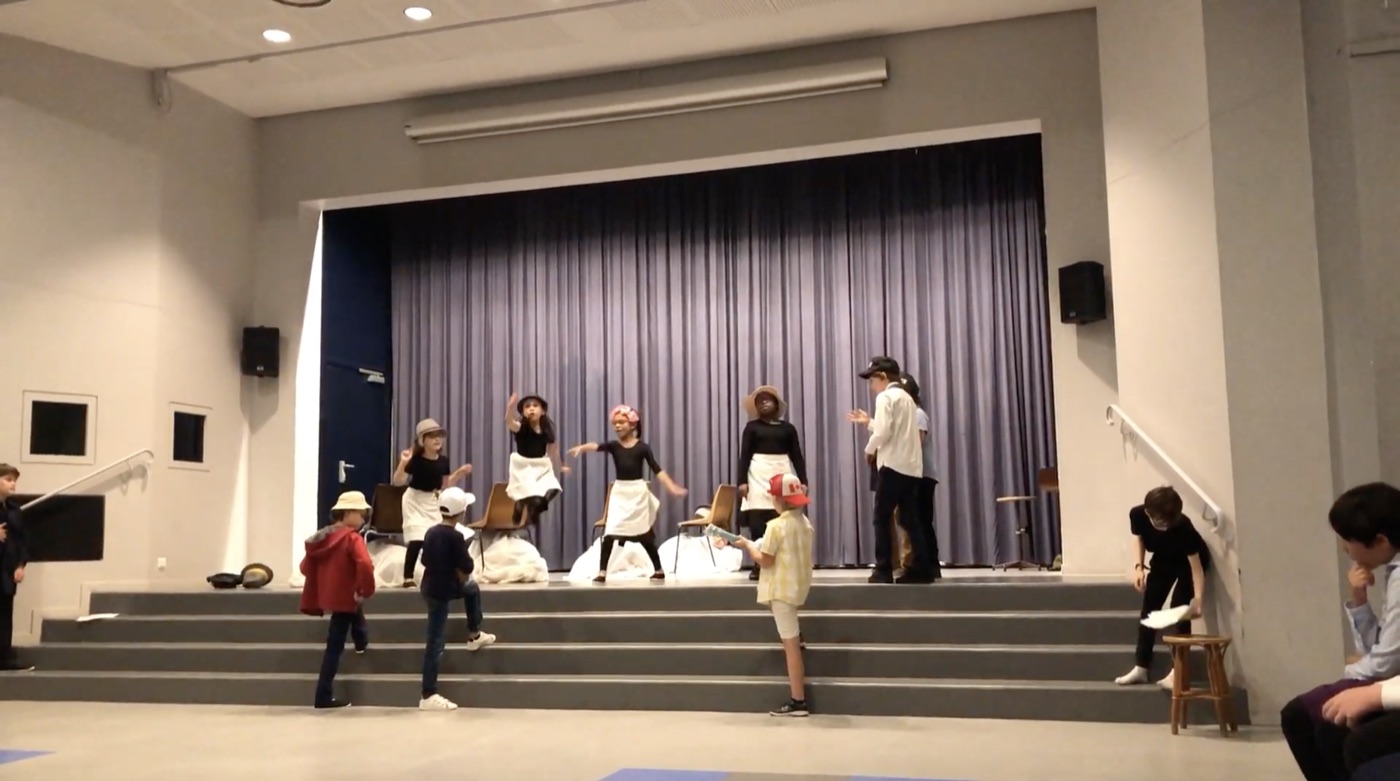 Groupe d'enfants jouant devant un rideau de théâtre